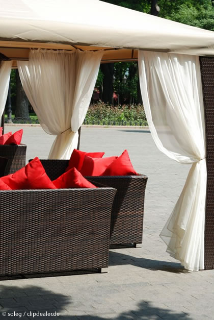 Lounge Möbel aus Polyrattan mit roten Kissen