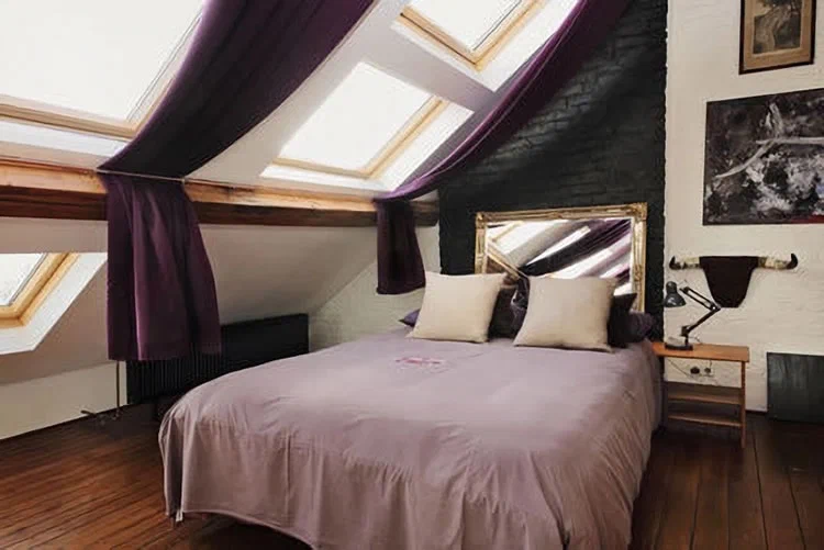 Schlafzimmer mit Bett an der Dachschräge